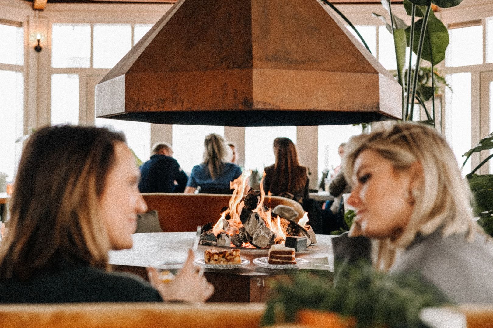 Twee vriendinnen praten bij de brandende open haard van NIUS