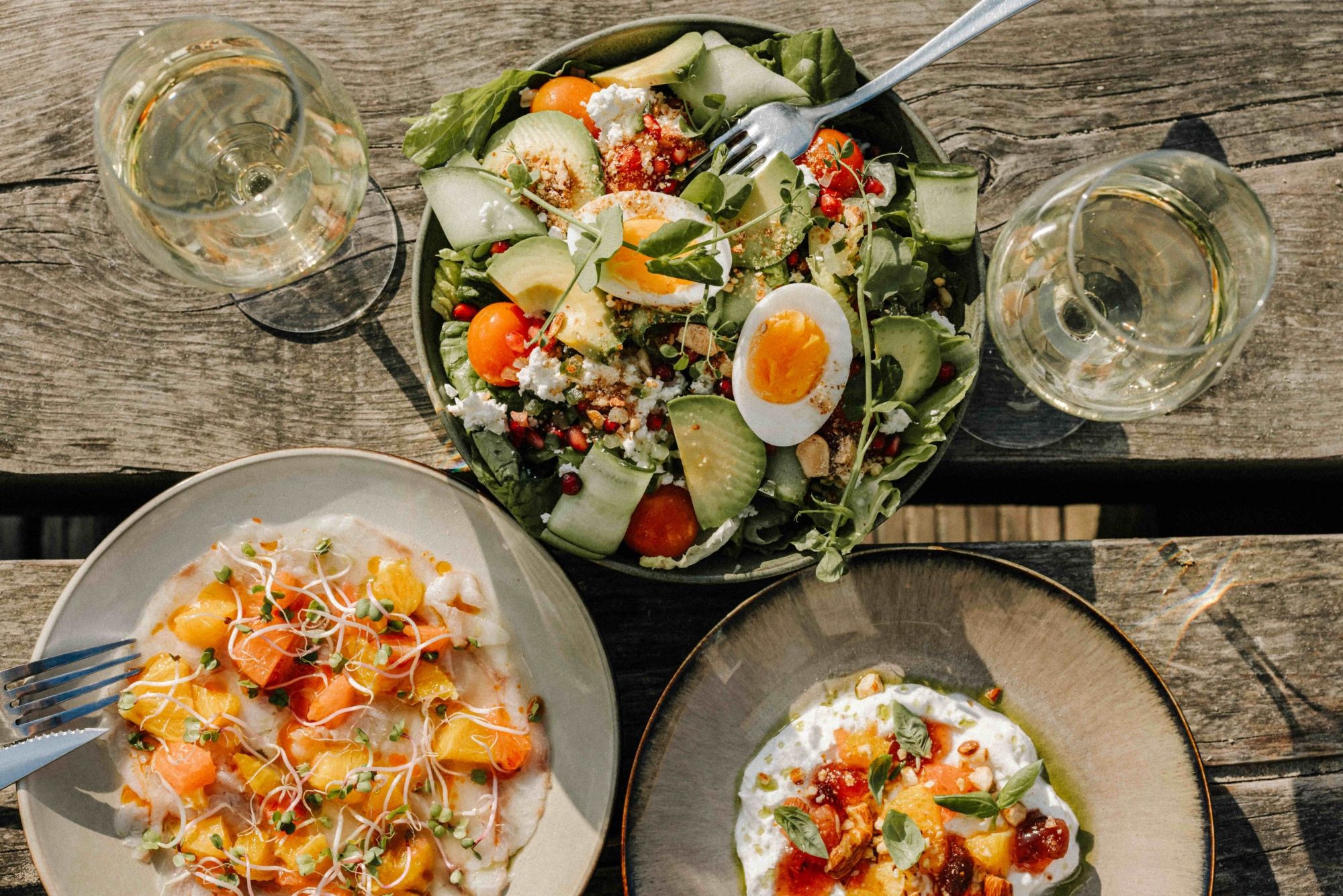 Salades en glazen wijn op een houten tafel