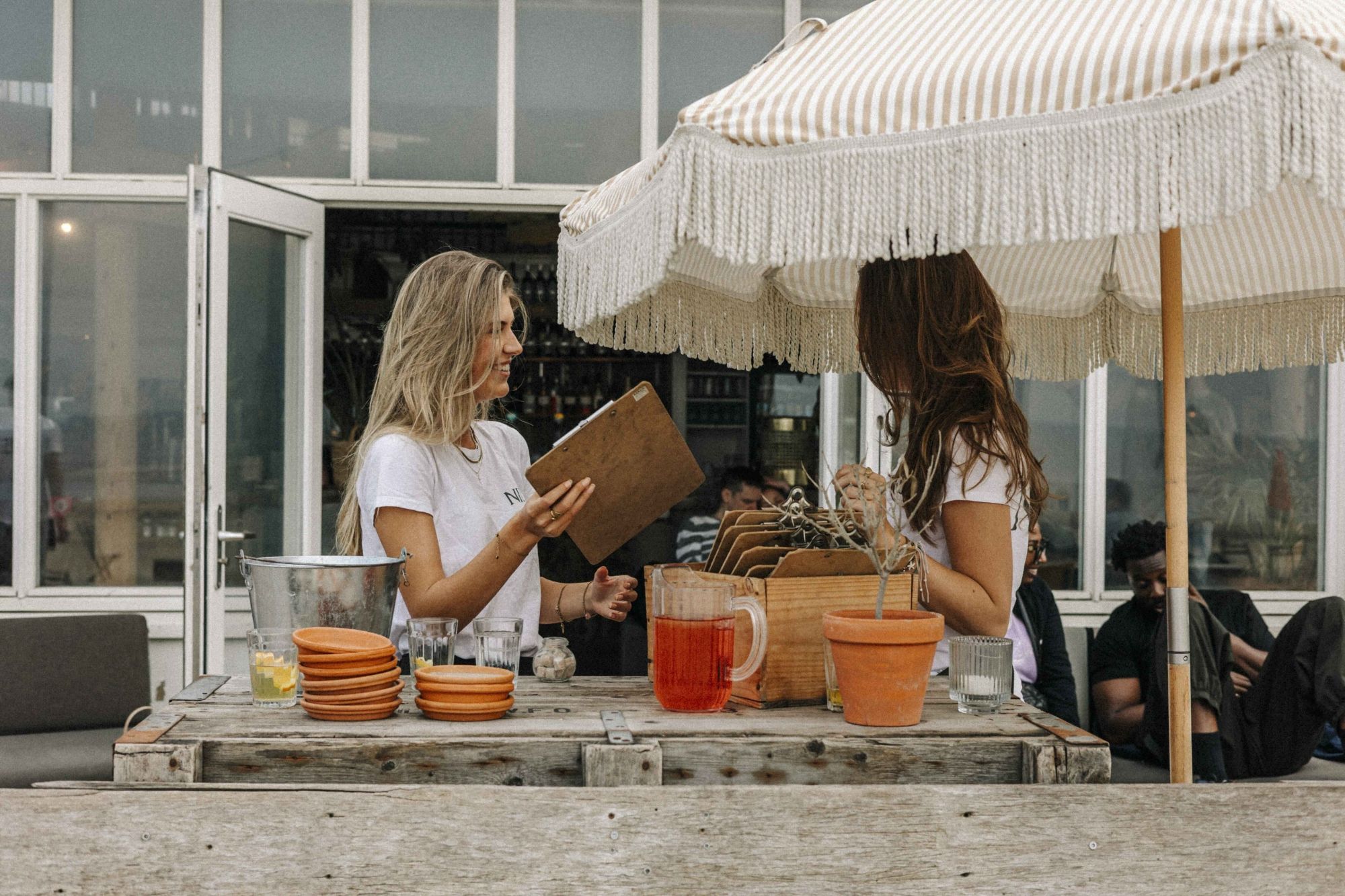 Twee gasten onder een parasol op het terras