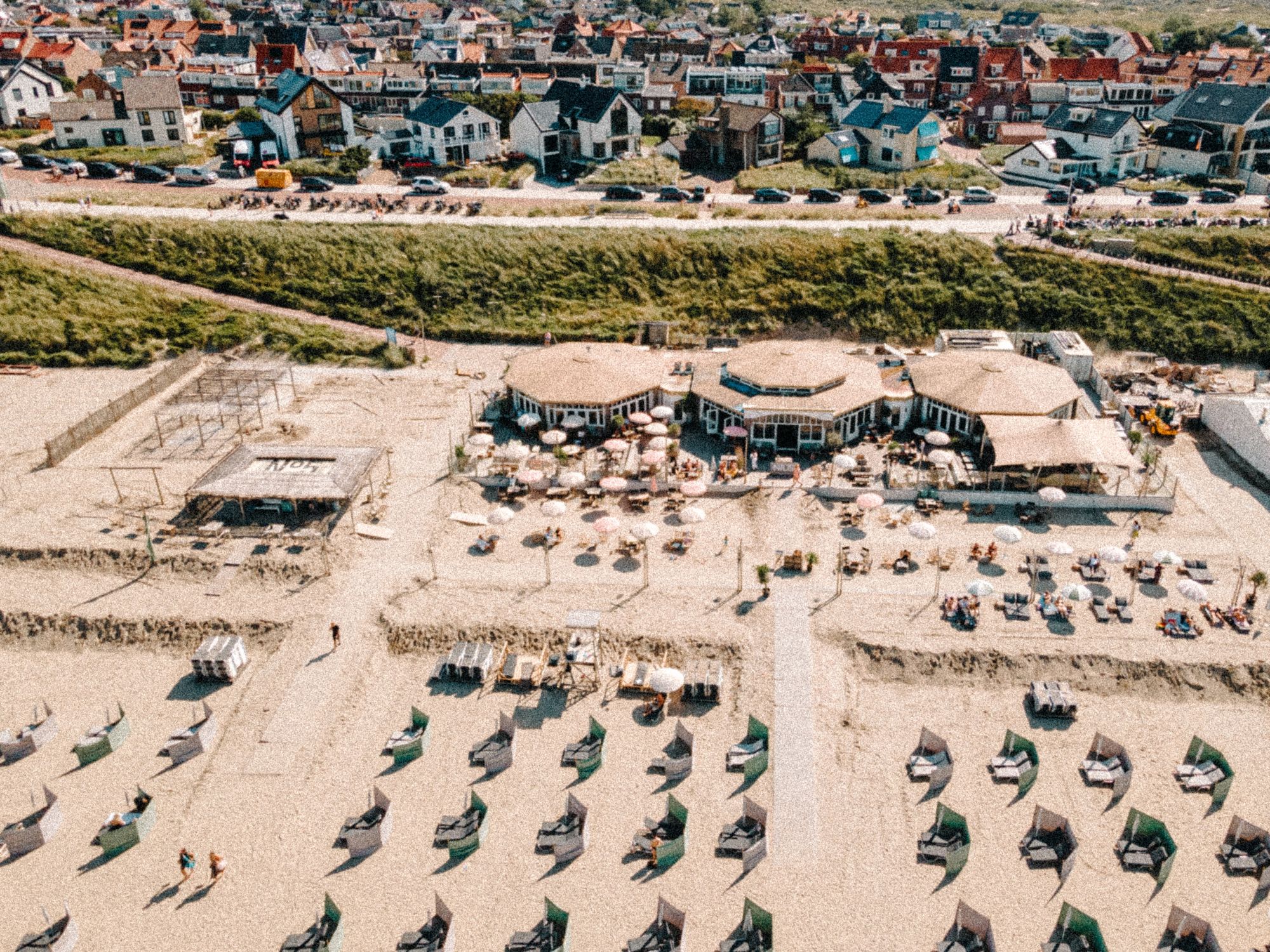 NIUS en de rijen strandbedjes op het zand, vanuit de lucht