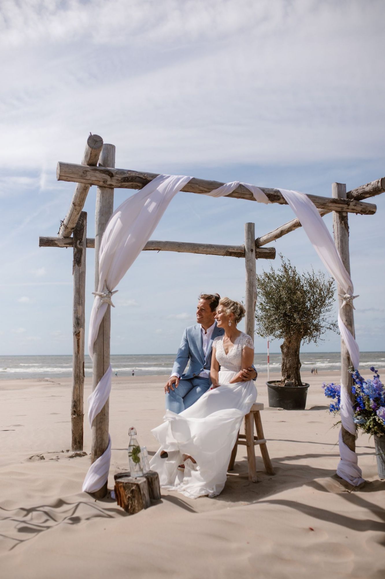 Een bruidspaar onder het prieel op het strand