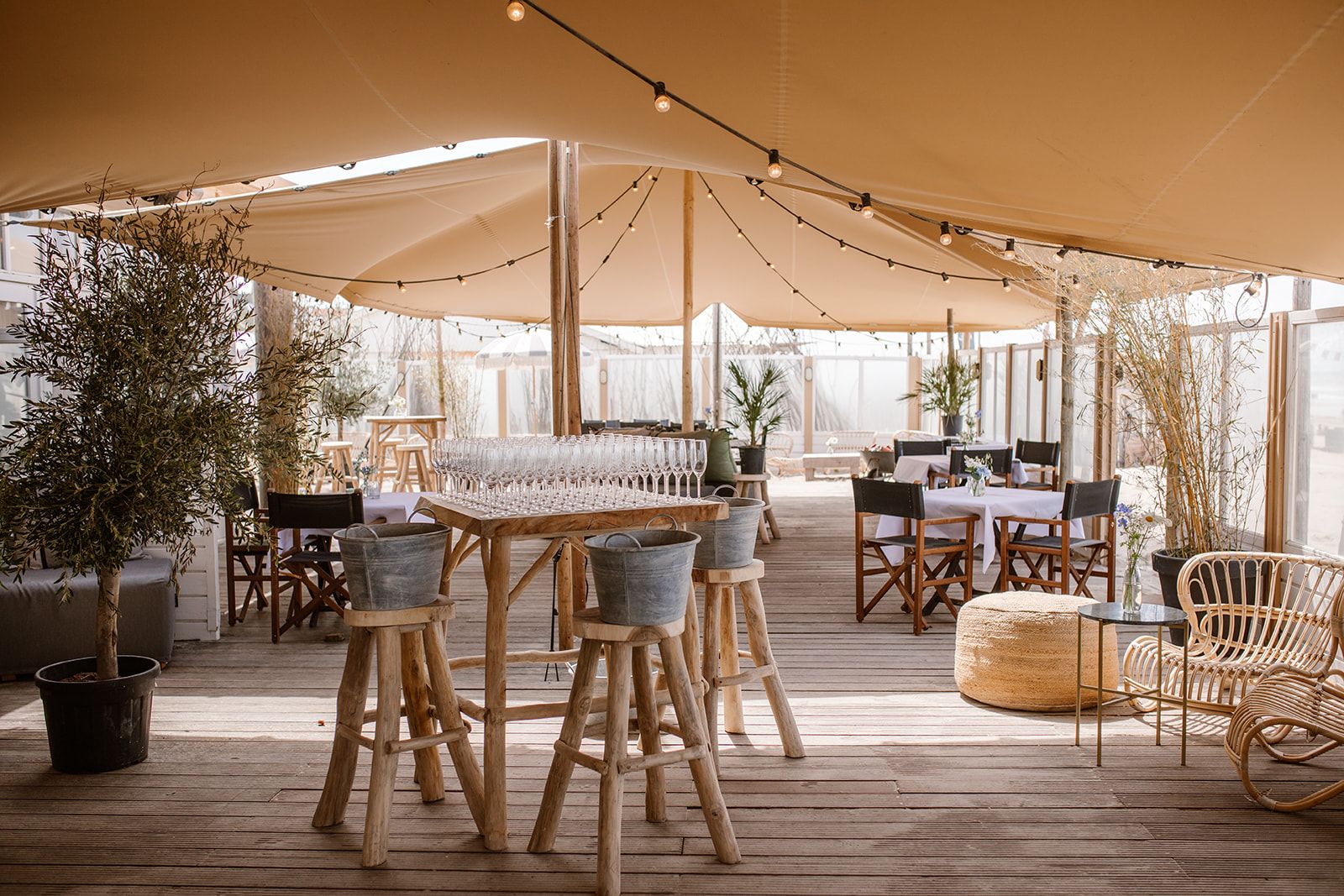 Gedekte tafels en lichtjes onder het tentdoek bij NIUS